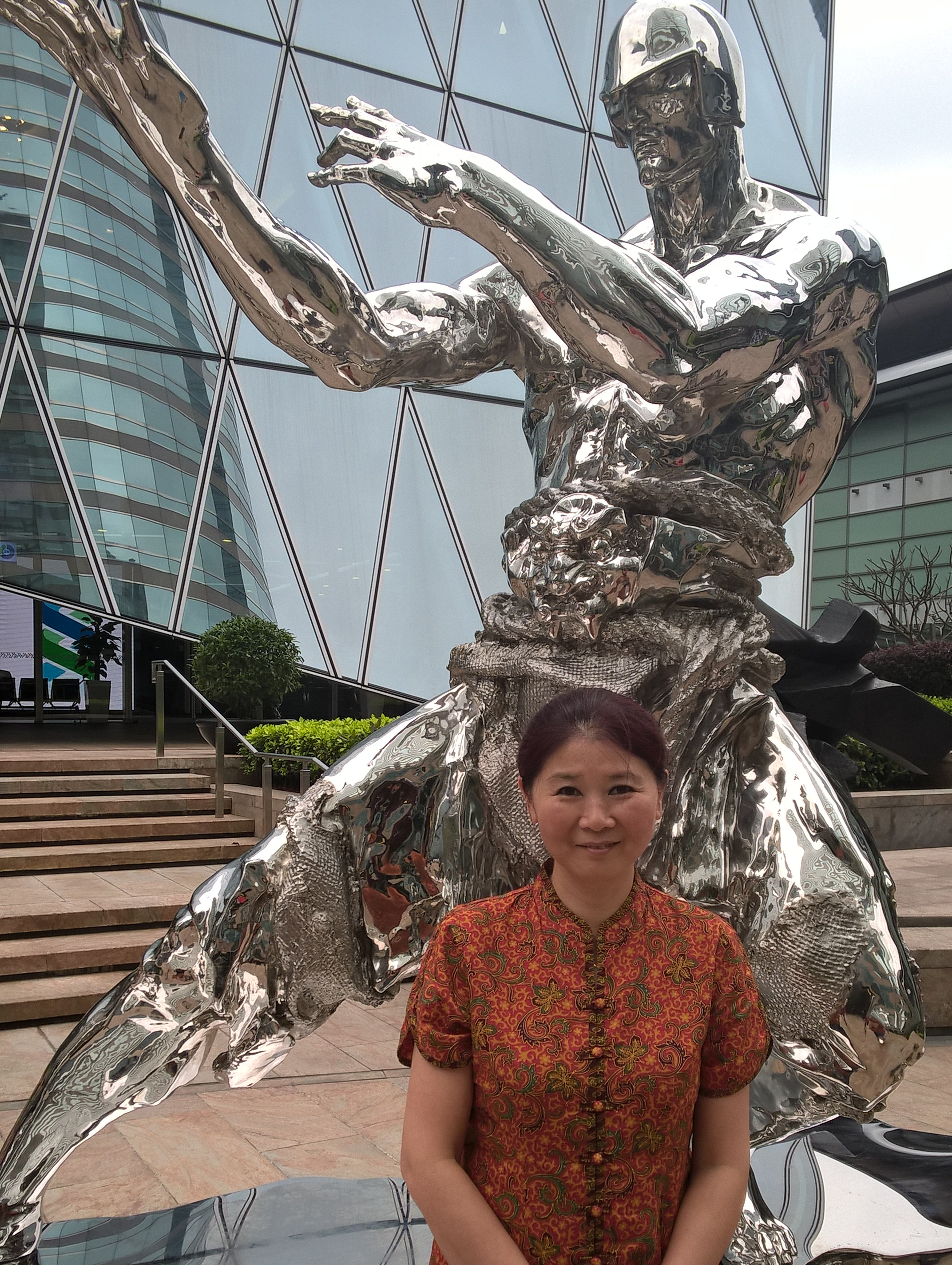 Honghong Xu vor der Skulptur "Über den Wolken" in Hongkong